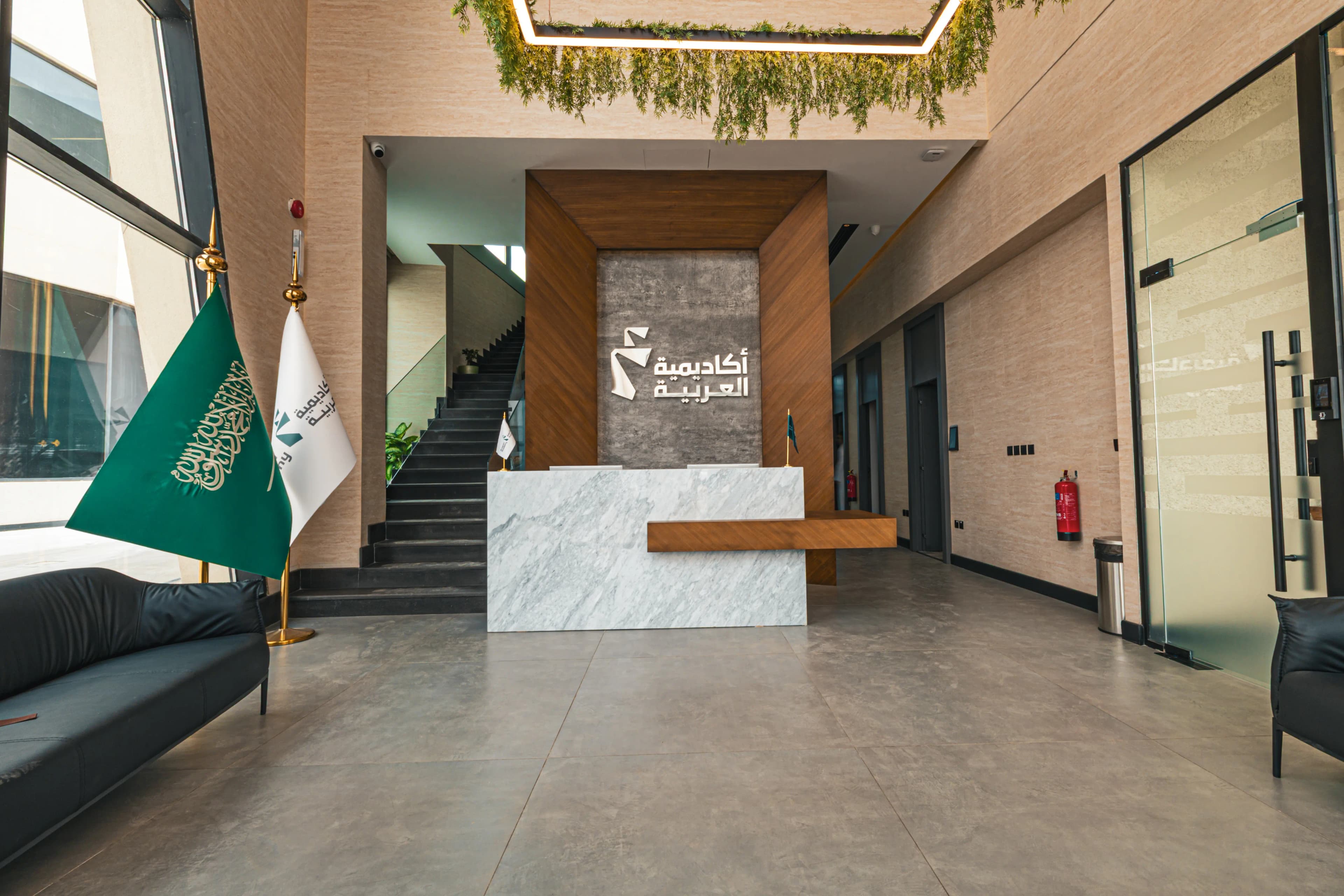 Corporate lounge with leather seating and glass wall overlooking palms